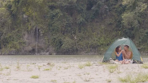 Tourist couple drinking tea inside tourist travel at lake shore on waterfall Stock Footage 112460972