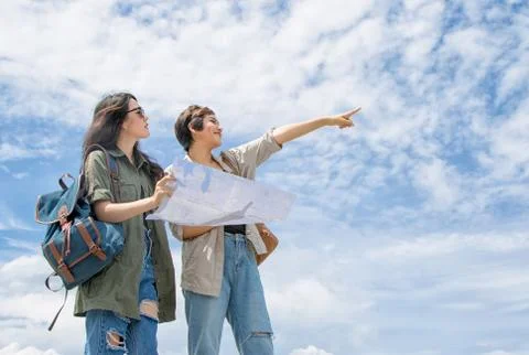 Tourist couple using a map for find location under blue sky Stock Photos