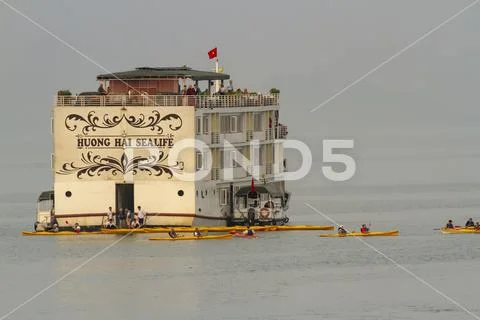 Tourist cruise ship and kayakers in Ha Long Bay Vietnam Stock Photos