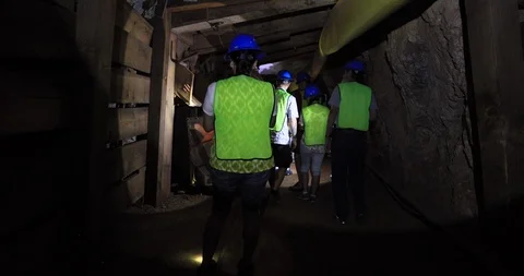 Tourist deep in Hard rock mining tunnel deep underground 4K Stock Footage 111989596