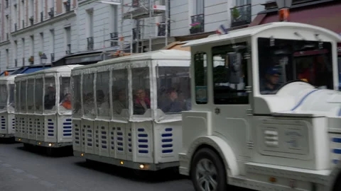 Tourist excursion train driving through a narrow street with outdoor cafes Stock Footage 336723639