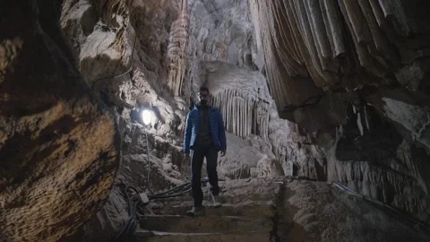 Tourist explore a cave with a beautiful background Stock Footage 243805501