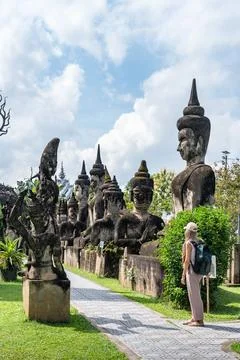 Tourist exploring ancient statues at buddha park vientiane Stock Photos