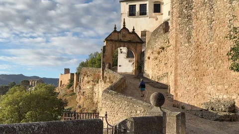 Tourist exploring the old town walking up an ancient archway in Ronda, Spain Stock Footage 337069819