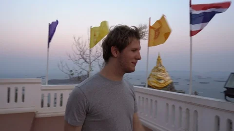 Tourist Exploring Thai Temple on Top of Mountain Hitting Large Gong Bell Stock Footage 126575482