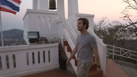 Tourist Exploring Thai Temple on Top of Mountain Hitting Large Gong Bell Stock Footage 126575950
