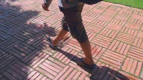 A tourist (farang) with a backpack is walking in flipflops on the red tiles  Stock Footage 308894975