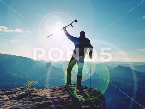 Tourist with forearm crutch above head on trail. Hurt hiker achieved mounta Stock Photos