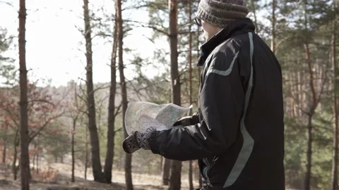 A tourist in a forest area goes on a map to a place of deployment Stock Footage 119438246