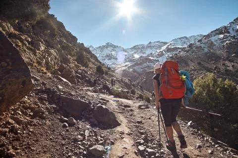 Tourist girl backpacker walking on the tourist path into the Atlas mountains Stock Photos