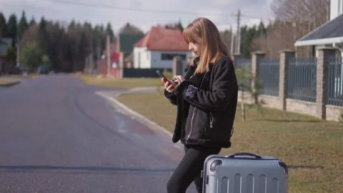 Tourist girl using smartphone while waiting for taxi Stock Footage 314611869