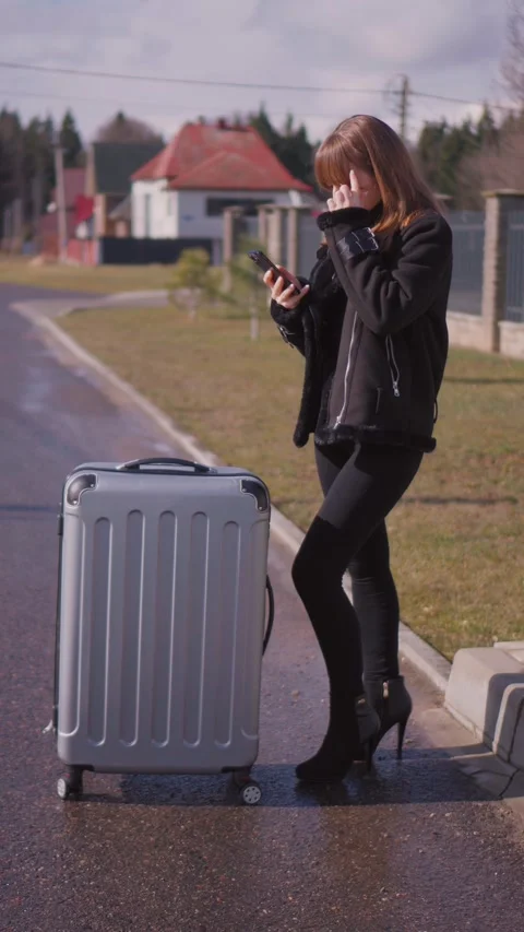 Tourist girl using smartphone while waiting for taxi Stock Footage 314647179