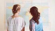 Tourist Girls Looking At World Map Planning Travel Adventure Stock Footage