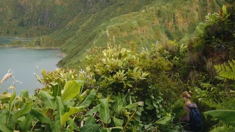 Tourist goes down the mountain path with a beautiful view of the mountain lake Stock Footage 104600024