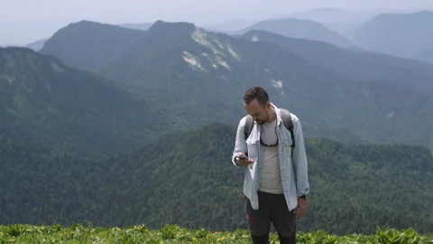 Tourist guide a man with a backpack studying the route on phone Stock Footage 152540037