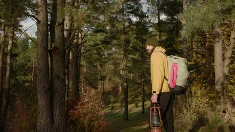Tourist on a hiking trail in the forest with a backpack and a lamp. Stock Footage 220188683