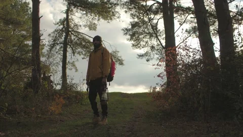 Tourist on a hiking trail in the forest with a backpack and a lamp. Stock Footage 220188754