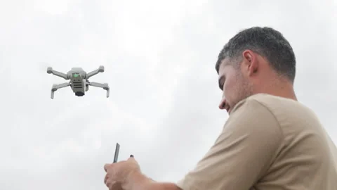 Tourist holds drones remote control. Traveler surveys sights from air using Stock Footage 322565122