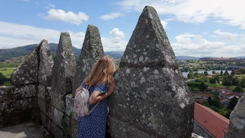 Tourist looking out over the defensive walls of Tui Cathedral in the province Stock Footage 286243905