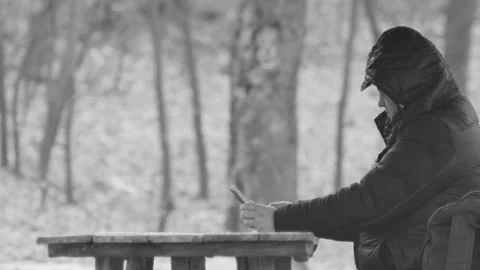Tourist looking at a tablet at a table in the forest, side view, in black an Vídeos de archivo 174843666