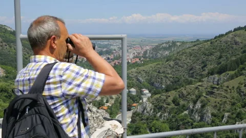 Tourist looking through binoculars Stock Footage 96125210