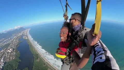 A tourist make skydiving with the Instructor over Barra da Tijuca beach. Vidéo 210867083
