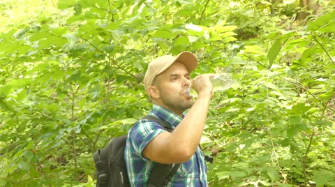 Tourist man close-up walking through the forest drinks water. man with backpa Video stock 65089839