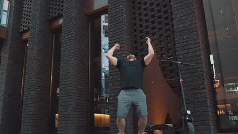 Tourist man with phone and e-scooter on background. A man raises his hands up Video stock 229257936