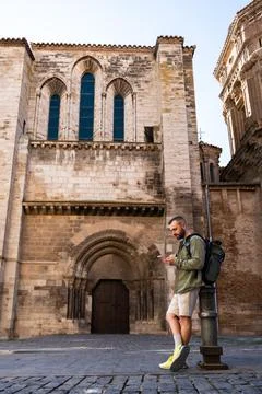 Tourist man using smartphone in front of cathedral of tudela, navarre, spain Stock Photos