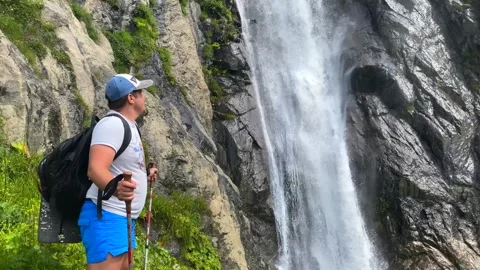 Tourist observing Shdugra waterfall in side view near Mazeri Stock Footage 343768325