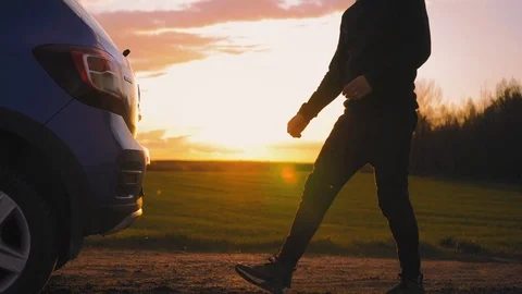 The tourist opens the trunk of the car in the middle of the field at sunset Stock Footage 95337401