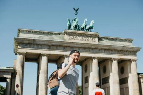Tourist or a guy with a backpack talking on a mobile phone. Stock Photos
