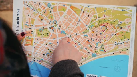 A tourist with a paper map points out landmarks with finger. Travel concept. Stock Footage 335807305