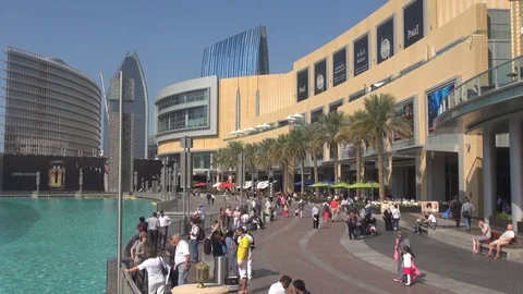 Tourist people enjoy Dubai shopping mall promenade exotic Khalifa lake palm tree Stock Footage
