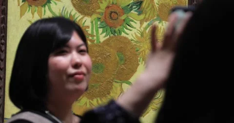Tourist posing for photo in front of Van Gogh Sunflowers painting Stock Footage 321019238