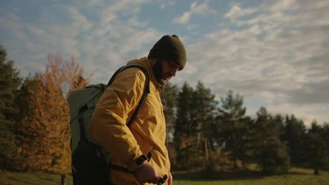 A tourist puts on a backpack after stopping in the mountains. Stock Footage 220189019