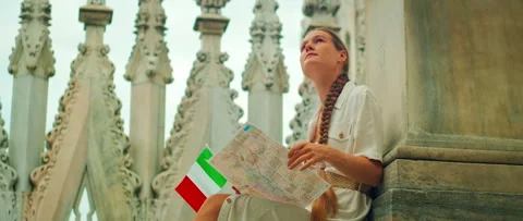 Tourist reading map and holding Italian flag on Duomo Milan Cathedral rooftop Stock-Footage 343378838