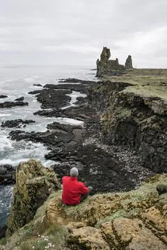 Tourist In Red Jacket At Londrangar Cliffs in Iceland Stock Photos