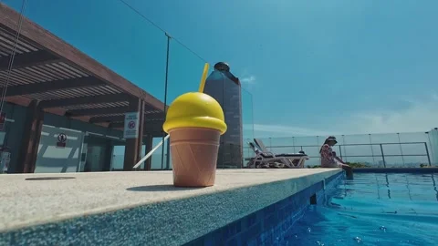 Tourist relaxing by the rooftop pool with refreshing drink on summer day Stock Footage 305358080