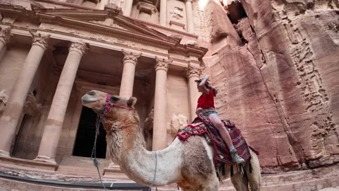 Tourist riding camel exploring Petra Treasury ancient city Jordan Stock Footage 313494326
