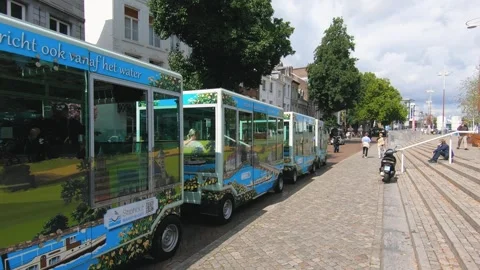 Tourist road train driving through a sunny European street Stock Footage 323391193