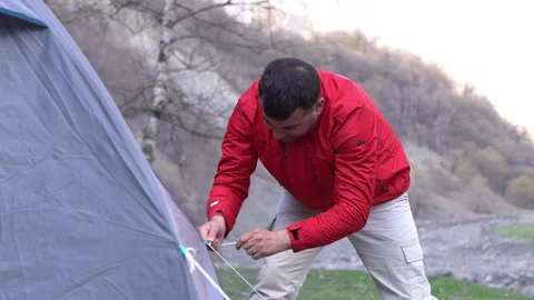 Tourist Securing Tent Ropes Video stock 303659875