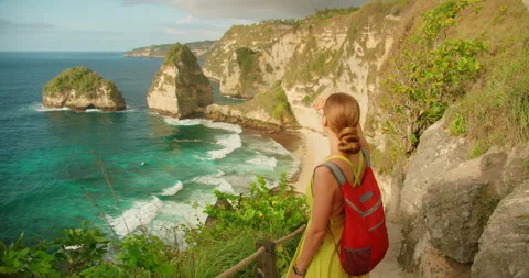 Tourist shielding eyes from sun while viewing ocean and Diamond Beach at Nusa Stock-Footage 327756272