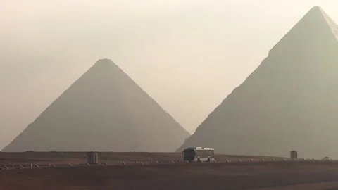 Tourist shuttle bus driving inside the Giza Pyramid Complex with pyramids in the Stock Footage 341837916