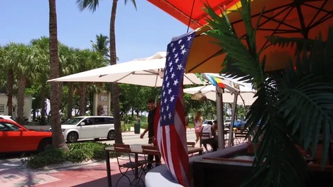Tourist sitting at pavement cafe while others walking beside it Stock Footage 116908986