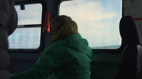 A tourist sitting at the window inside a small boat to St Kilda, Scotland Stock Footage 229333382