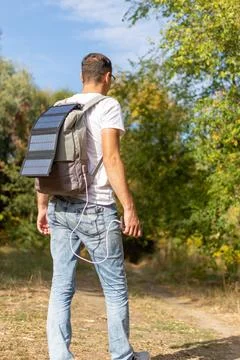 Tourist with solar panel on backpack Stock Photos