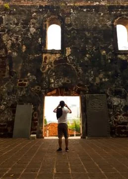 Tourist standing in the middle of the ruins of an old church. Stock Photos