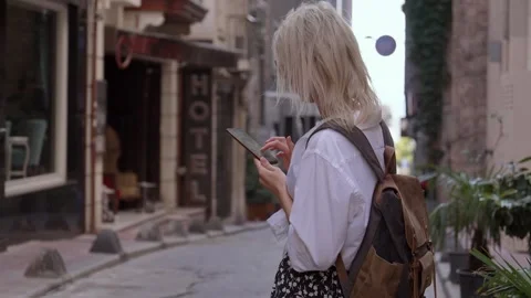 Tourist in stylish clothes and backpack, standing alone on street sign hotel. 動画素材 252896641