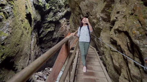 Tourist taking photos while walking in a mountain gorge Stock Footage 137486995